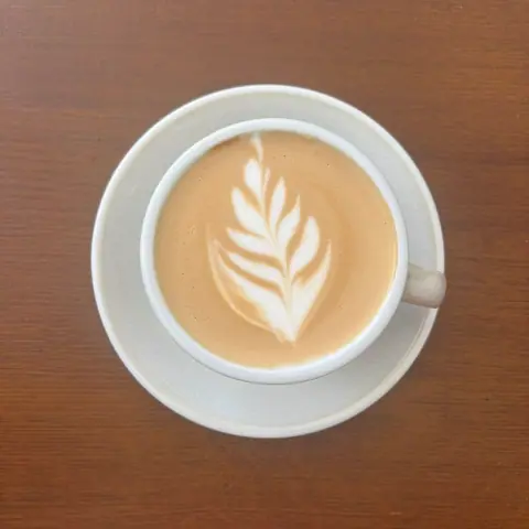 Cappuccino with latte art on a dark wooden table