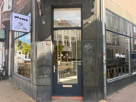 The corner storefront of Café momo with the hanging sign
