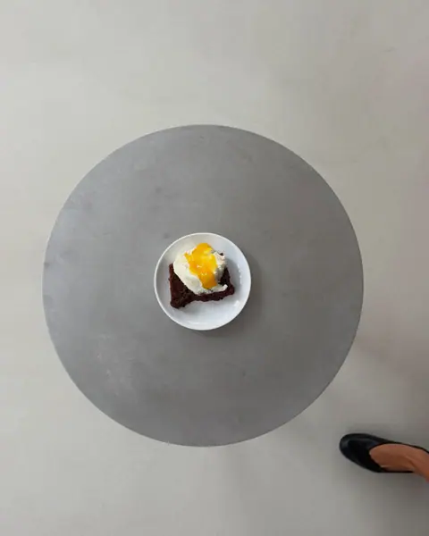 Dessert plates with cream and fruit on the round table, seen from above
